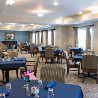 A spacious and elegantly decorated dining room with neatly arranged tables and chairs.