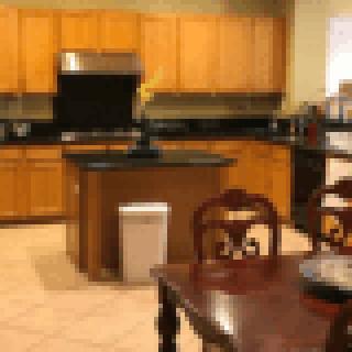 A kitchen with wooden cabinets and a central island next to a dining table.