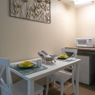 A small dining area with a set table and a microwave on the counter.