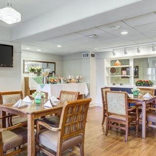 A well-lit dining area with multiple tables and chairs, ready for service.