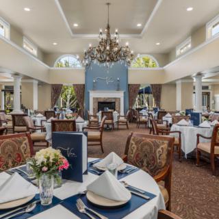 An elegantly decorated dining room with formal place settings and a chandelier.