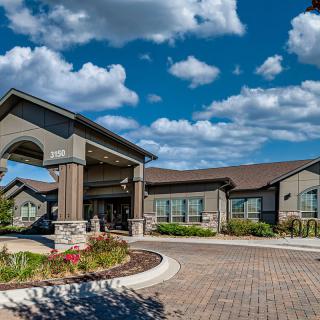 A modern building with an inviting entrance under a cloudy blue sky.