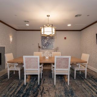 A modern dining room with a stylish table and chairs, illuminated by a chic chandelier.