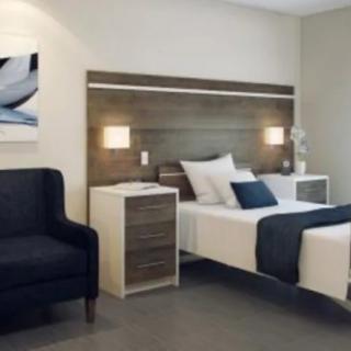 A modern bedroom with stylish decor, featuring a comfortable bed and a cozy armchair.