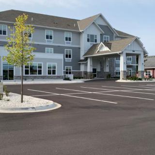A modern building with an empty parking lot in front.