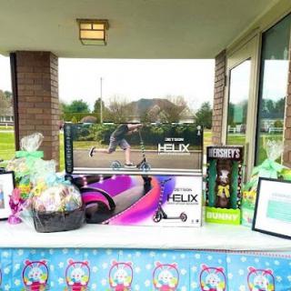 A colorful outdoor setup featuring a variety of gifts and toys, perfect for an Easter celebration.