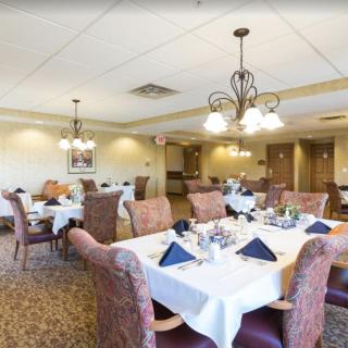 A well-furnished dining room with elegantly set tables and comfortable seating arrangements.