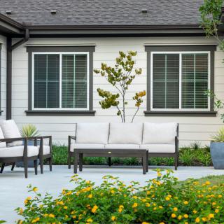 A modern patio setup with outdoor furniture and a well-maintained garden.