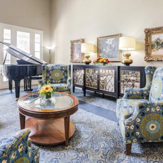 Elegant living room featuring a grand piano, stylish furniture, and artistic decor.