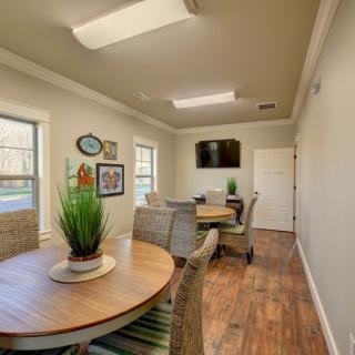 A cozy meeting room with a round table, chairs, and decorative plants.