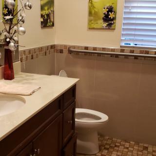 A neatly arranged bathroom with a countertop, sink, and toilet.