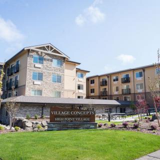 Exterior view of a hotel with landscaped grounds and a prominent sign.