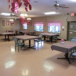 A spacious dining area set up with tables and chairs, featuring light decor and ample natural light.