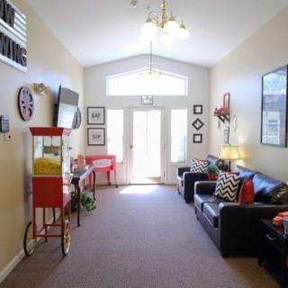 A cozy living room with couches, a popcorn machine, and decorative elements.