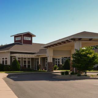 A welcoming residential facility showcasing modern architecture and well-maintained landscaping under a clear blue sky.