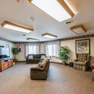 A cozy living room with comfortable sofas, a television, and natural lighting.