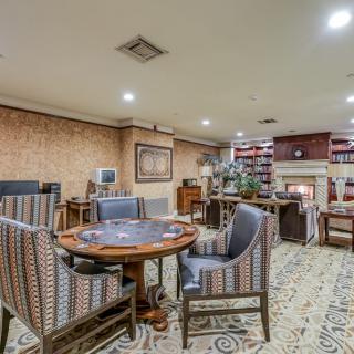 Cozy living room with a round table, upholstered chairs, and a fireplace.