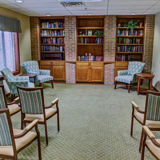 A cozy library with bookshelves and a seating area.