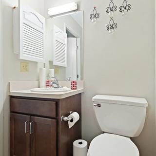 A clean and simple bathroom with a toilet, sink, and wall decor.