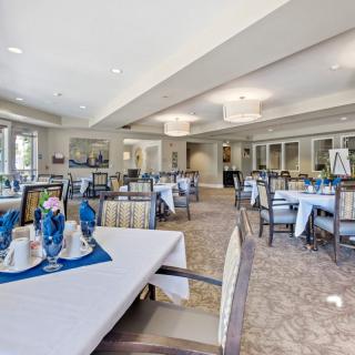 An elegant dining area with neatly set tables and chairs, ready for guests.