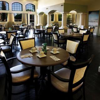 An empty restaurant dining area with neatly arranged tables and chairs.
