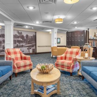 A cozy lounge area featuring colorful armchairs and a central coffee table, ideal for relaxation.