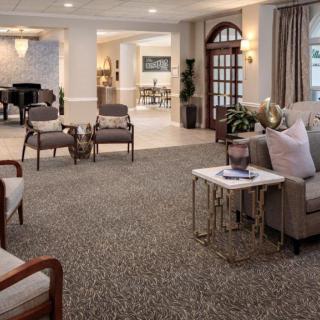 A luxurious living room interior with comfortable seating and a grand piano.