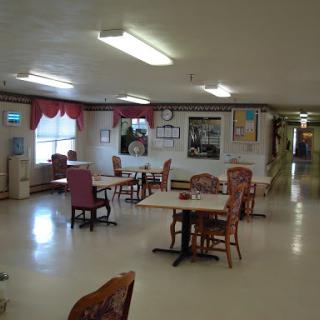 A spacious dining area featuring tables and chairs, designed for communal gatherings.