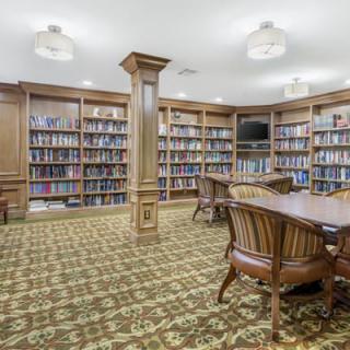 A cozy library with wooden bookshelves and comfortable seating.