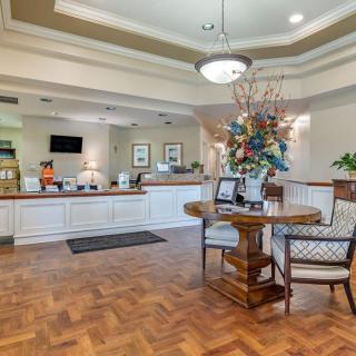 A well-lit reception area featuring a front desk, comfortable seating, and elegant floral arrangements.