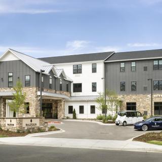 A modern residential building with a parking area in front.