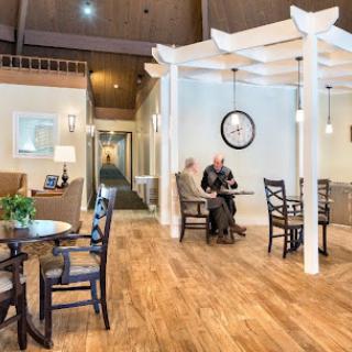 A cozy indoor waiting area with elegant furniture and a warm wooden floor.