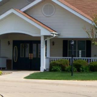A suburban residential house with a porch and well-maintained lawn.