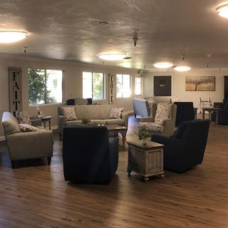 A spacious and modern living room with multiple seating arrangements and large windows providing natural light.