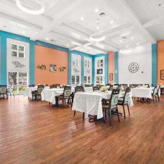 A spacious and elegantly decorated dining room with neatly arranged tables and chairs.