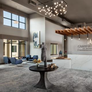 A spacious, modern lobby with contemporary furnishings and a statement chandelier.
