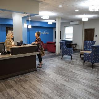 A modern reception area with two people having a conversation at the desk.