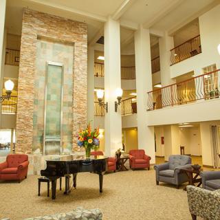 Spacious hotel lobby with elegant seating and a grand piano.