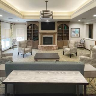 A modern and spacious living room with comfortable seating and a central fireplace.