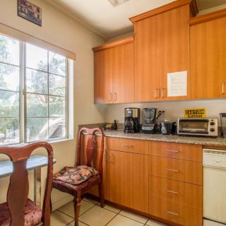 A cozy kitchen with wooden cabinets, a countertop with appliances, and a window providing natural light.