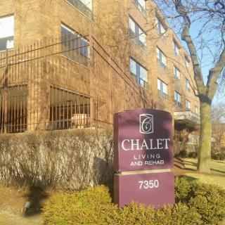 The Chalet apartment building with a welcoming sign.