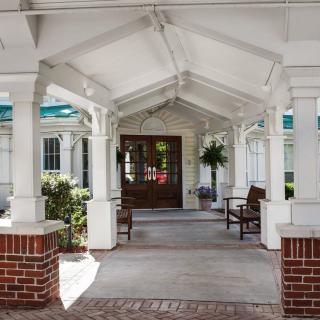 Covered entrance with benches and plants.