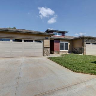 A modern suburban house with a three-car garage and a concrete driveway.