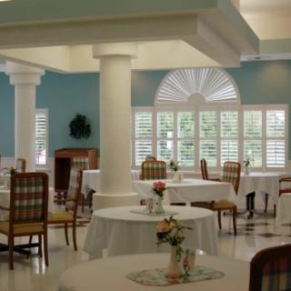 A bright and elegant dining area with tables, chairs, and large windows.