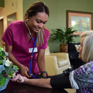A nurse checks the blood pressure of an elderly patient in a warm and inviting healthcare environment.