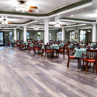 A spacious dining area featuring wooden tables and chairs, designed for a comfortable dining experience.