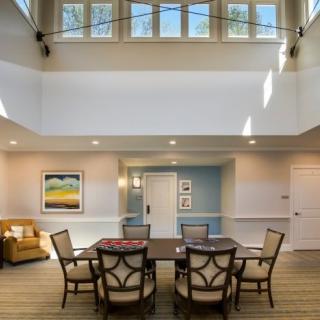 A well-lit dining area with elegant furniture and decorative artwork on the walls.