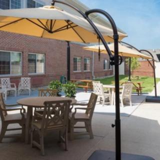 A sunny patio area featuring tables and chairs with large umbrellas.