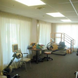 A rehabilitation room equipped with various exercise machines and equipment.