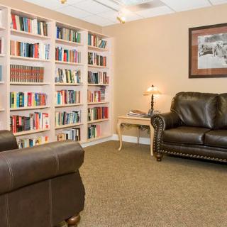 A cozy reading area with leather chairs and bookshelves.